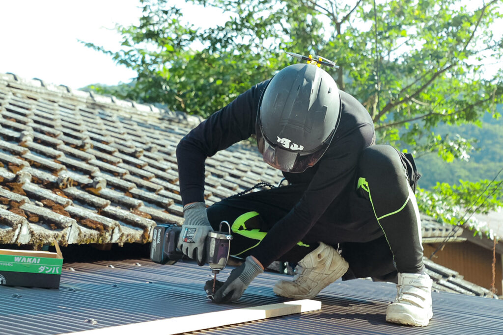 屋根にねじを打つ作業